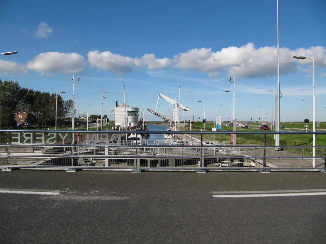 De Grevelingensluis met open brug en vaartuigen, gezien vanaf de weg.