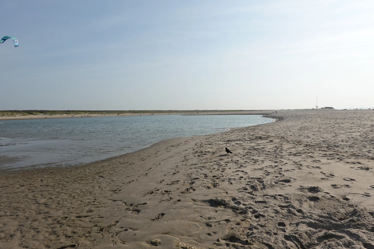 Een lagune met zandige oevers en een blauwe lucht.