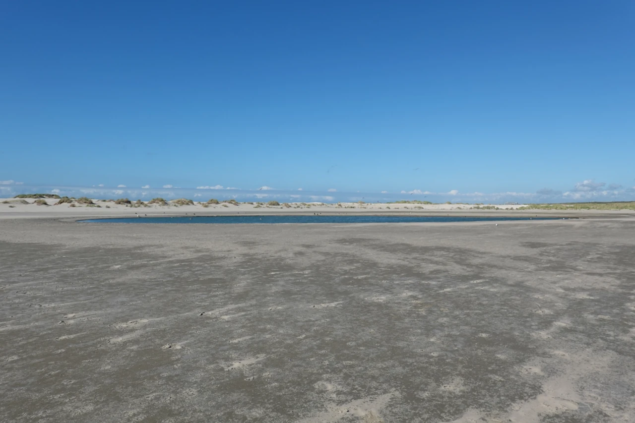 Een waterplas tussen zandbanken bij de Zandmotor.